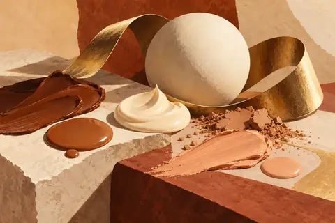 Complexion products on stone with a gold ribbon